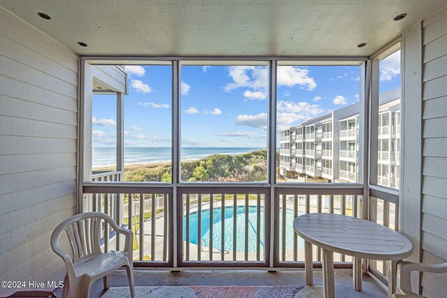 balcony with a water view and a beach view