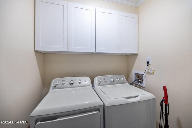 washroom featuring cabinets, crown molding, and washing machine and clothes dryer