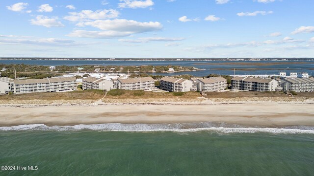 birds eye view of property featuring a water view and a beach view