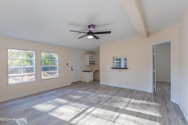 unfurnished living room featuring ceiling fan, beamed ceiling, and light hardwood / wood-style floors