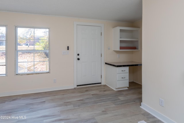 entryway featuring crown molding and light hardwood / wood-style flooring