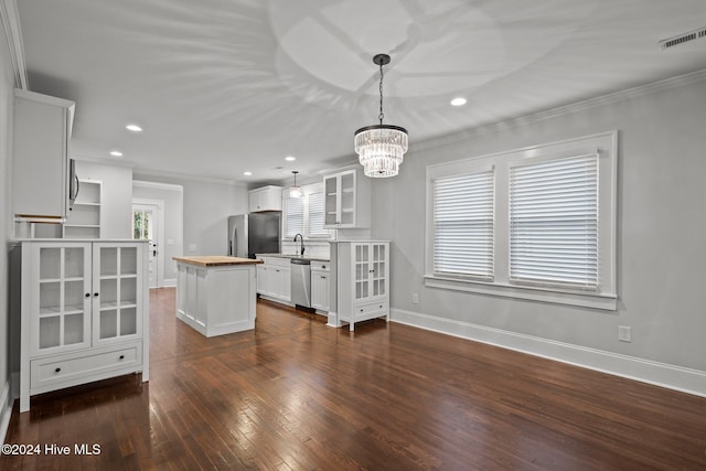 interior space featuring sink, crown molding, dark wood-type flooring, and a notable chandelier