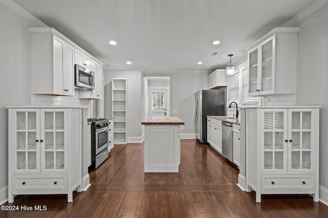 kitchen featuring white cabinets, appliances with stainless steel finishes, dark hardwood / wood-style floors, and decorative light fixtures