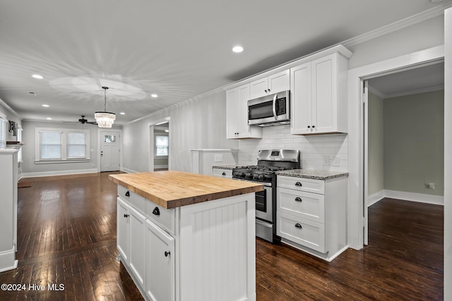 kitchen featuring stainless steel appliances, a center island, dark hardwood / wood-style floors, white cabinetry, and butcher block counters