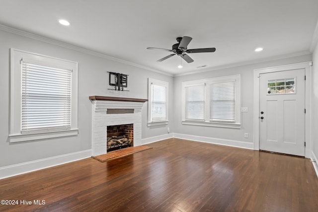 unfurnished living room featuring ceiling fan, dark hardwood / wood-style flooring, a fireplace, and crown molding