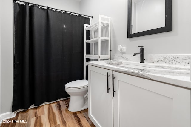 bathroom with wood-type flooring, toilet, and vanity