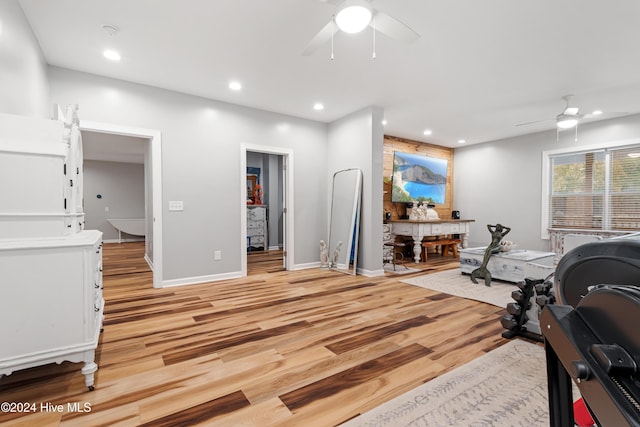 workout room featuring ceiling fan and light hardwood / wood-style floors