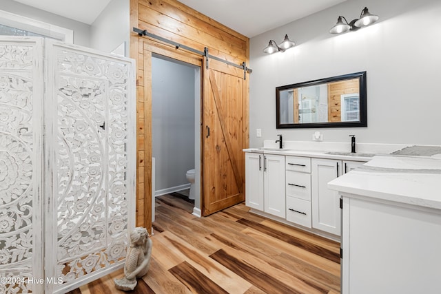 bathroom with walk in shower, wood-type flooring, toilet, and vanity