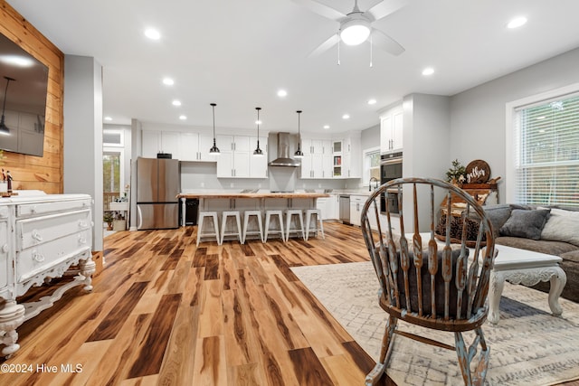 living room with ceiling fan, sink, and light hardwood / wood-style floors