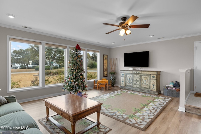 living room with ceiling fan, a healthy amount of sunlight, crown molding, and light hardwood / wood-style flooring