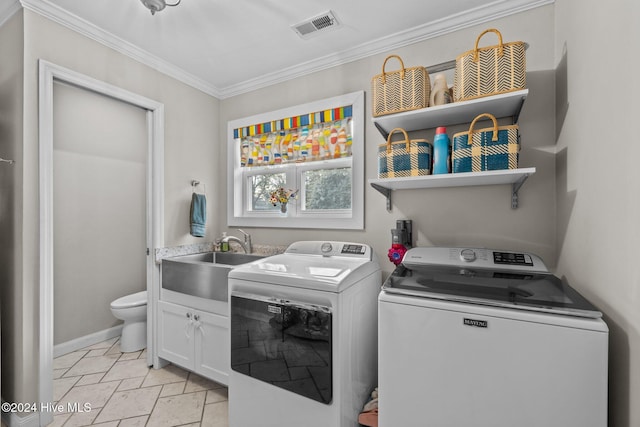 laundry area featuring cabinets, separate washer and dryer, crown molding, and sink