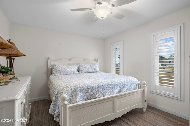 bedroom featuring ceiling fan, dark hardwood / wood-style flooring, and multiple windows