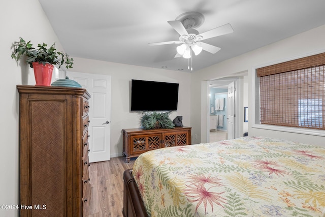 bedroom featuring ceiling fan, ensuite bath, and light hardwood / wood-style flooring