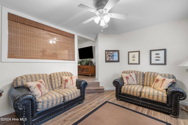 living room with light hardwood / wood-style flooring and ceiling fan