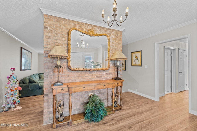 interior space featuring hardwood / wood-style floors, a textured ceiling, crown molding, and an inviting chandelier