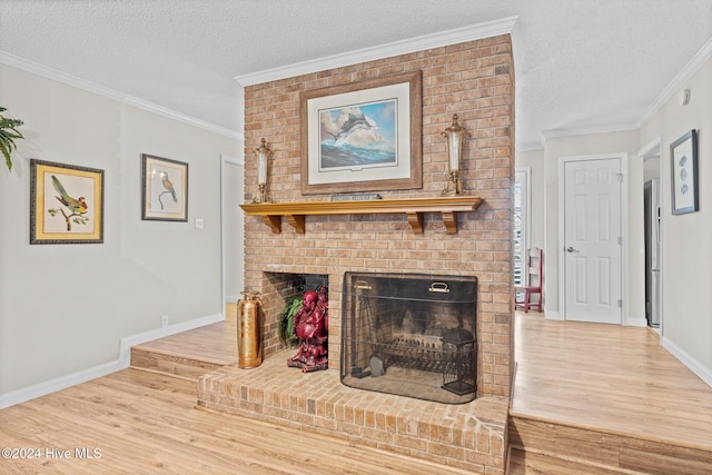 living room featuring hardwood / wood-style floors, crown molding, a brick fireplace, and a textured ceiling