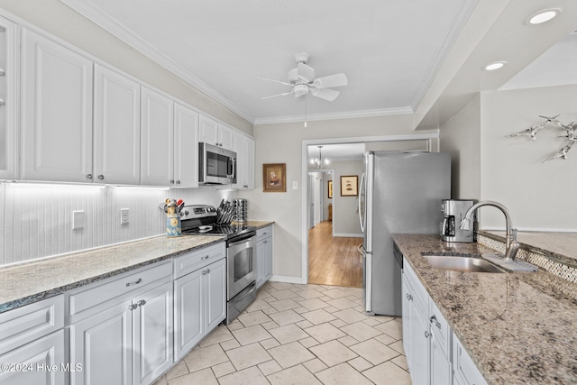 kitchen with white cabinets, appliances with stainless steel finishes, crown molding, and sink