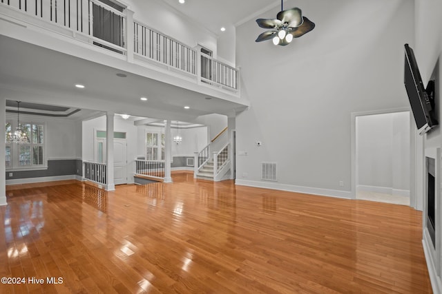 unfurnished living room featuring hardwood / wood-style flooring, plenty of natural light, and a high ceiling