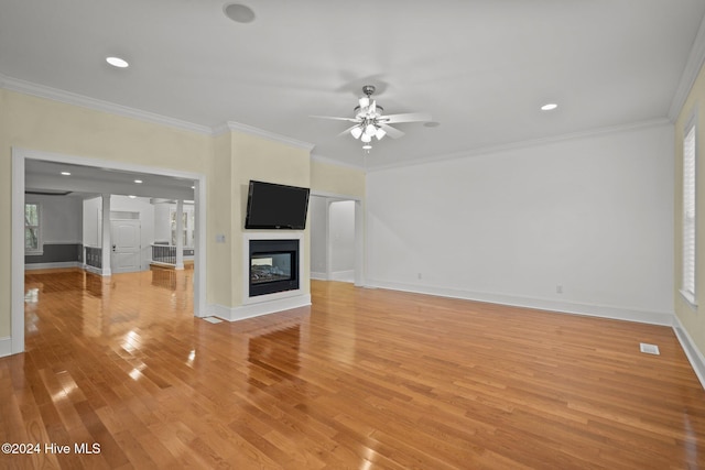 unfurnished living room with a multi sided fireplace, light hardwood / wood-style floors, and ornamental molding