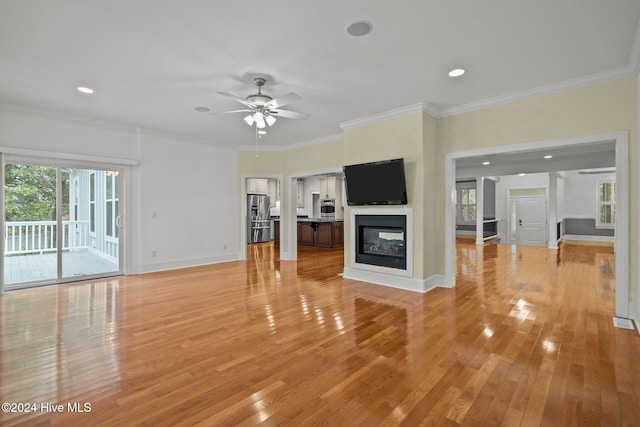 unfurnished living room featuring a multi sided fireplace, light hardwood / wood-style floors, ceiling fan, and ornamental molding