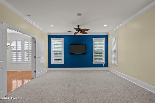 empty room with ceiling fan with notable chandelier, crown molding, and light carpet