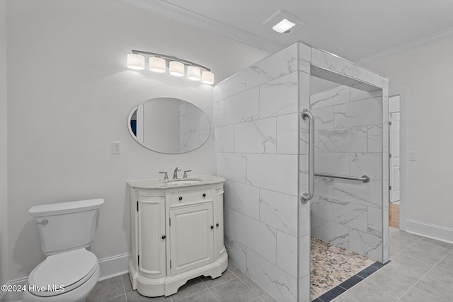 bathroom with vanity, tile patterned floors, toilet, ornamental molding, and a tile shower