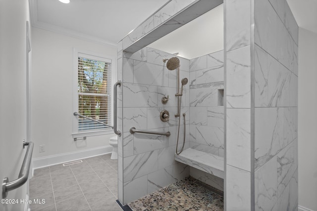 bathroom featuring a tile shower, crown molding, tile patterned floors, and toilet