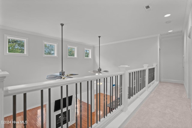 hallway with crown molding, plenty of natural light, and light hardwood / wood-style floors