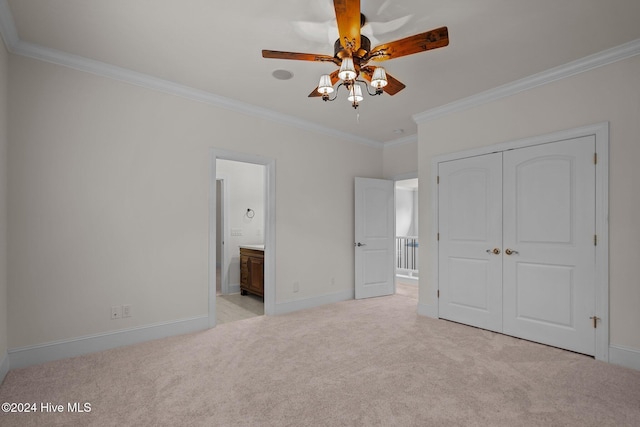 unfurnished bedroom featuring ensuite bath, ceiling fan, light colored carpet, and ornamental molding