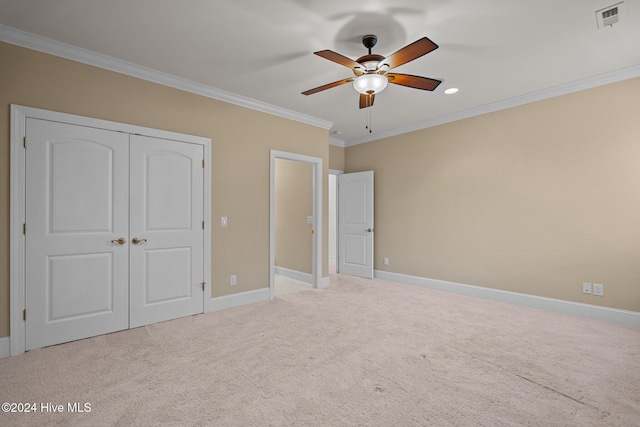 unfurnished bedroom featuring ceiling fan, ornamental molding, light carpet, and a closet