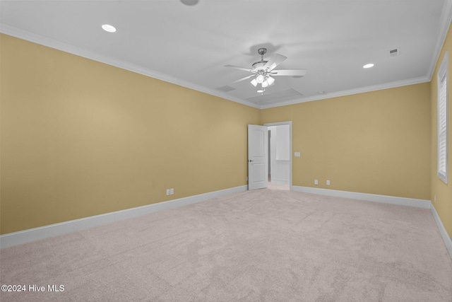 carpeted spare room with ceiling fan and ornamental molding