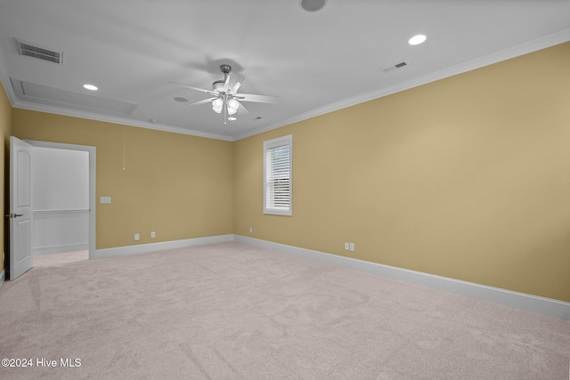 empty room with ceiling fan, light colored carpet, and ornamental molding