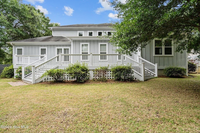 rear view of house featuring a lawn