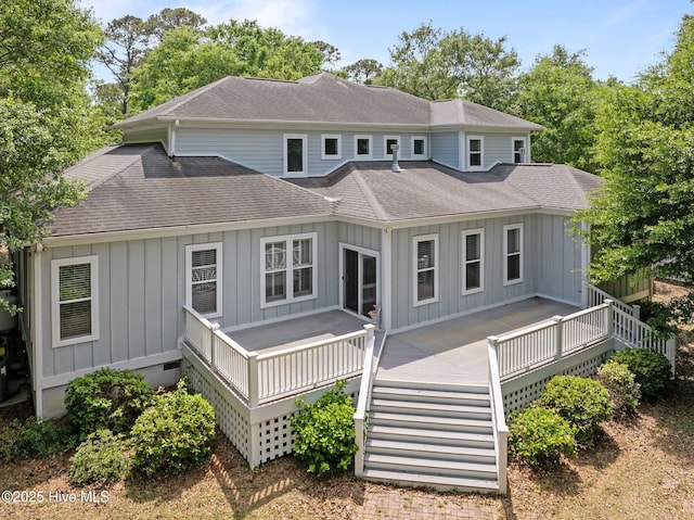 rear view of house featuring board and batten siding, a deck, and a shingled roof