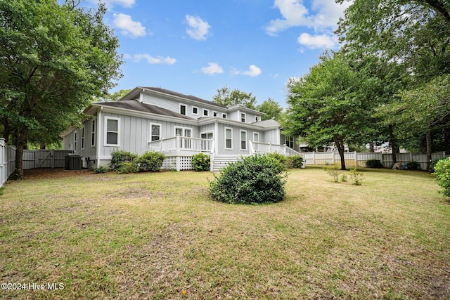 rear view of property featuring a lawn, a deck, and central AC