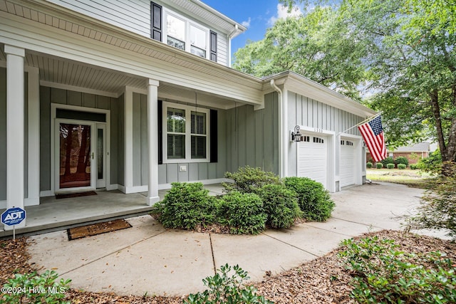 entrance to property with covered porch and a garage