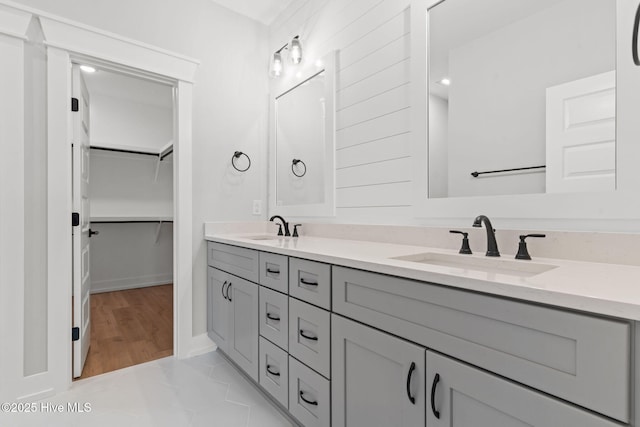 457 Raven Glen Dr, Southport, NC 28461 - bathroom with double vanity, a spacious closet, and baseboards