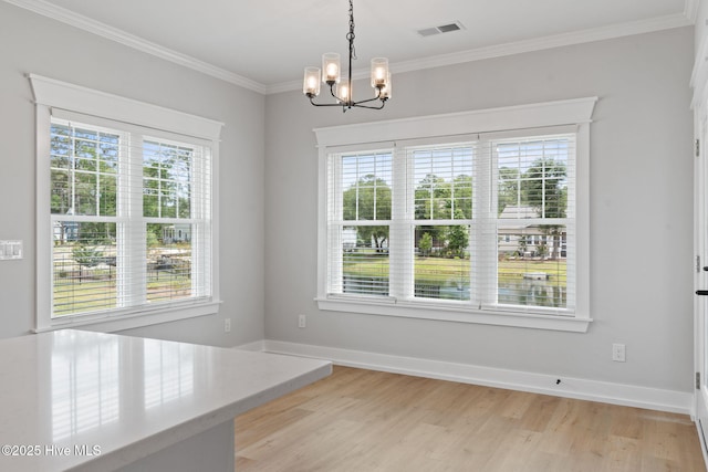 457 Raven Glen Dr, Southport, NC 28461 - unfurnished dining area with healthy amount of natural light, a chandelier, ornamental molding, light wood-style floors, and baseboards