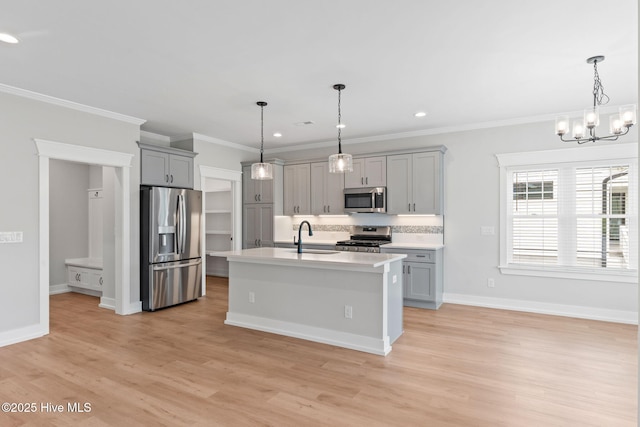 457 Raven Glen Dr, Southport, NC 28461 - kitchen with stainless steel appliances, gray cabinetry, a sink, light wood-type flooring, and light countertops