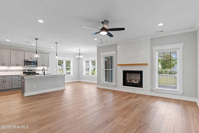 457 Raven Glen Dr, Southport, NC 28461 - unfurnished living room featuring a sink, a ceiling fan, a fireplace, light wood-type flooring, and recessed lighting