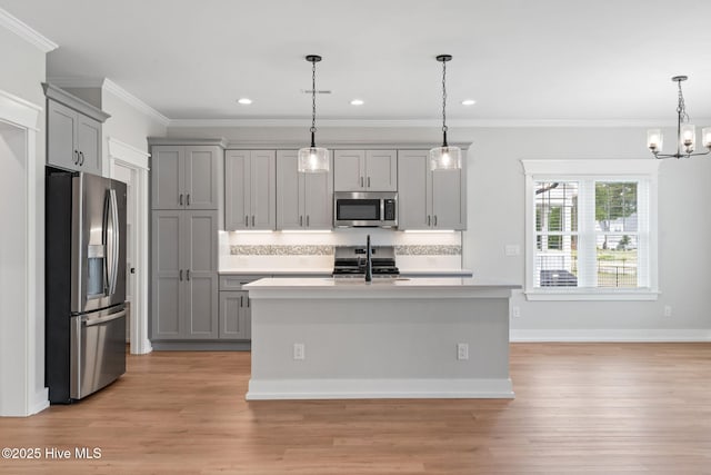 457 Raven Glen Dr, Southport, NC 28461 - kitchen with stainless steel appliances, gray cabinets, light countertops, ornamental molding, and light wood finished floors