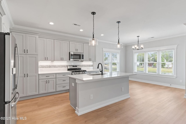 457 Raven Glen Dr, Southport, NC 28461 - kitchen featuring stainless steel appliances, a sink, a chandelier, light countertops, and light wood-type flooring