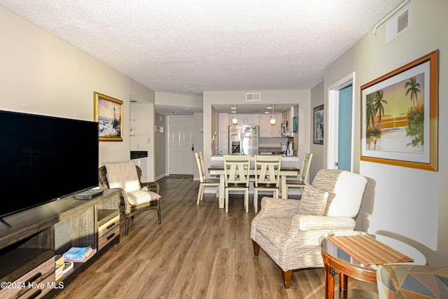 living room with a textured ceiling and hardwood / wood-style flooring