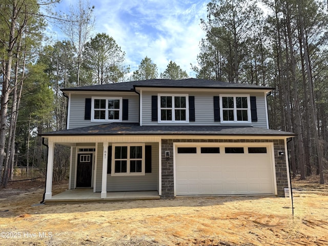 view of front of house with stone siding, a porch, and an attached garage