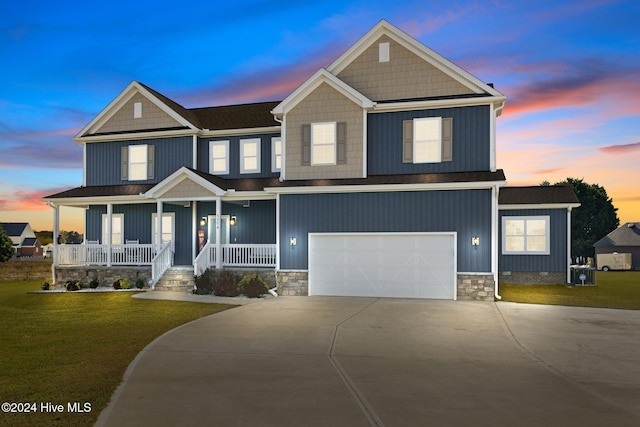 craftsman inspired home with a yard, covered porch, and a garage