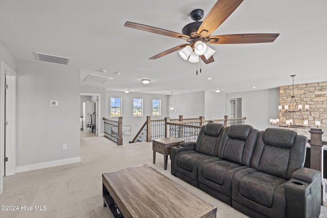 living room with ceiling fan with notable chandelier and light colored carpet