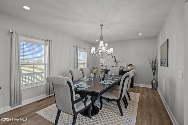 dining room with dark hardwood / wood-style floors and a notable chandelier