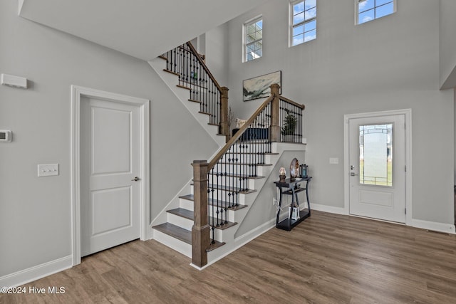 entrance foyer featuring a towering ceiling and hardwood / wood-style flooring