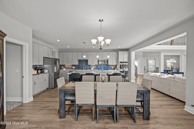 dining space featuring an inviting chandelier and light hardwood / wood-style flooring