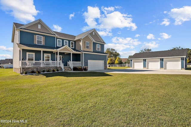 view of front of home featuring a front lawn, covered porch, an outdoor structure, and a garage